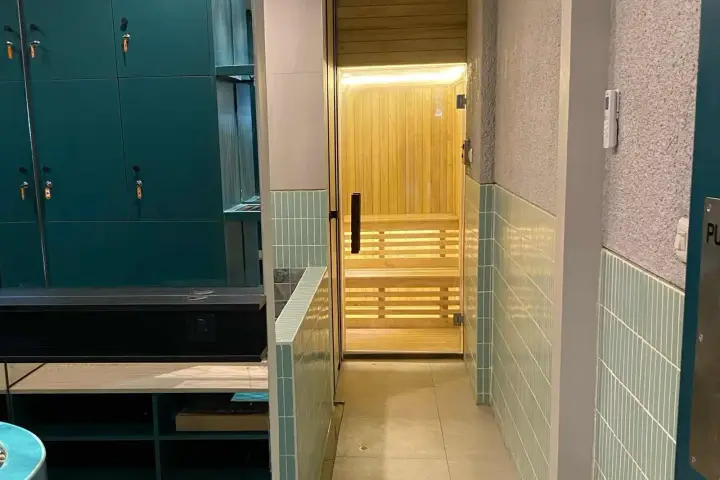 Teal lockers beside a timber sauna cabin