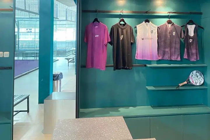 Merch wall with GOAT jerseys and a racket